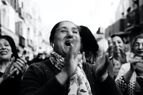 Woman clapping in a crowd